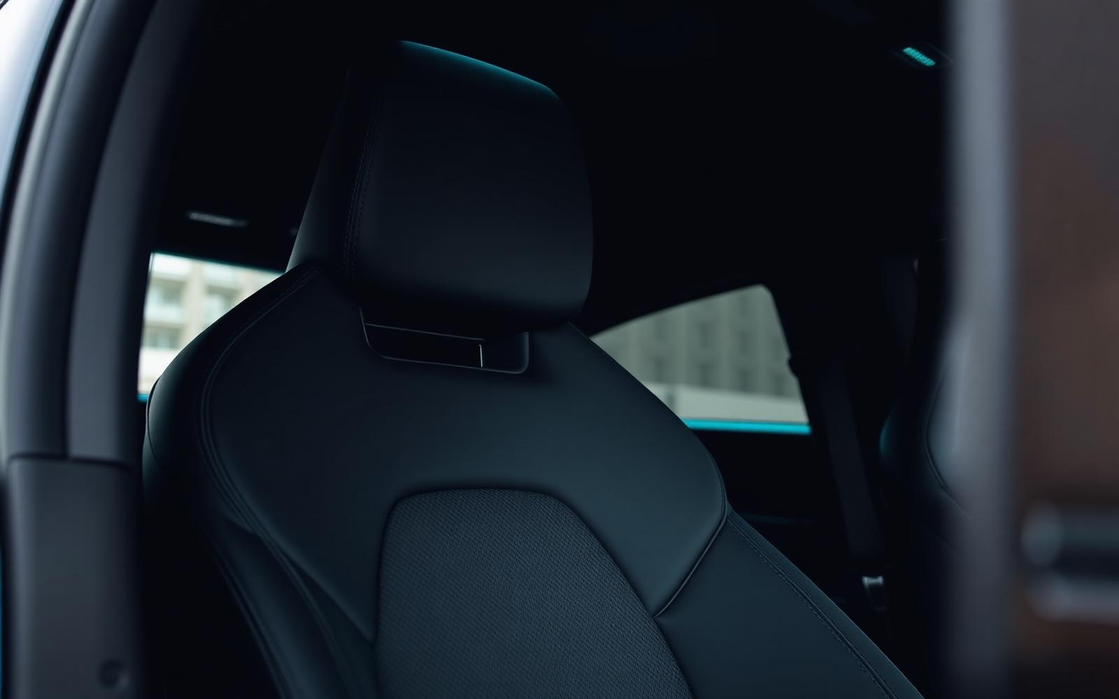 Detail of a modern car seat and headrest in a dark premium interior